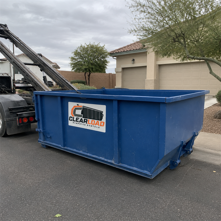 Roll-off dumpster being delivered to a cleanup site